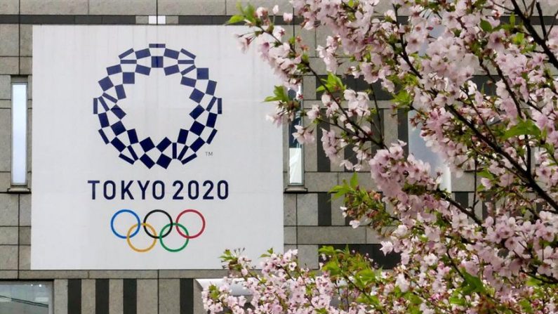Fotografía de archivo de un cartel con el logotipo de los Juegos Olímpicos de Tokio 2020 junto a un cerezo en flor el 6 de marzo de 2018, en Tokio (Japón). EFE/Kimimasa Mayama
