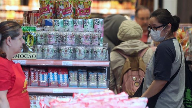 Fotografía fechada el 1 de marzo de 2020, que muestra a varias personas mientras compran con tapabocas, en el barrio de Liberdade, uno de los barrios con más presencia de población japonesa de Sao Paulo (Brasil). EFE/ Fernando Bizerra/ARCHIVO
