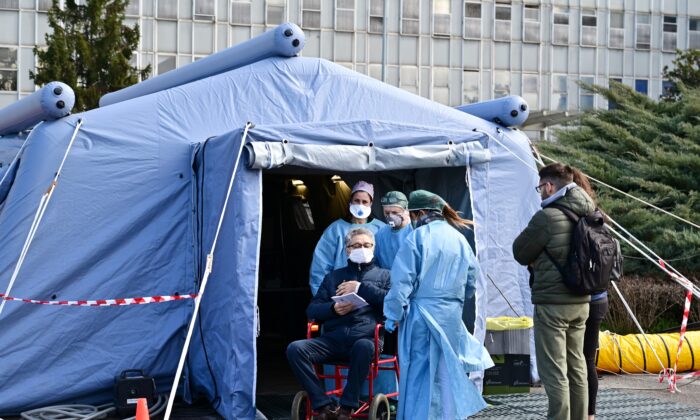 Un hombre recibe asistencia frente al hospital de Cremona, en Cremona, al norte de Italia, el 4 de marzo de 2020. (Miguel Medina/AFP vía Getty Images)