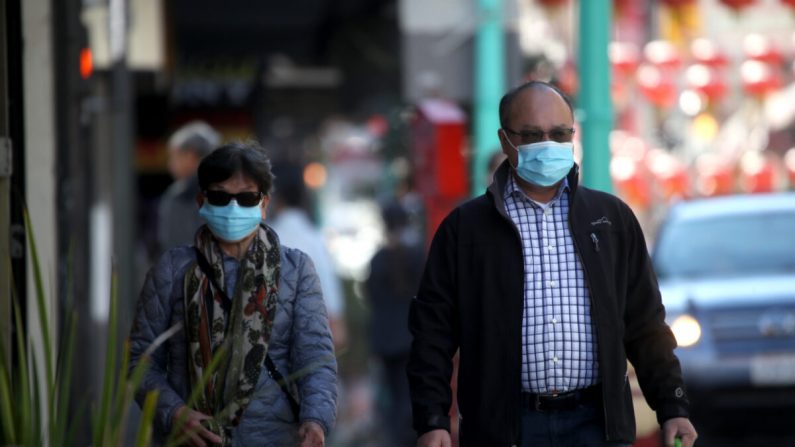 Personas usando máscaras quirúrgicas mientras caminan por Chinatown's Grant Avenue en San Francisco, California, el 26 de febrero de 2020. (Justin Sullivan/Getty Images)