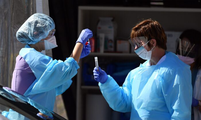Trabajadores médicos en el campus francés de Kaiser Permanente examinan a un paciente por el virus del PCCh, COVID-19, en una instalación de pruebas de conducción en San Francisco, California, el 12 de marzo de 2020. (Josh Edelson/AFP a través de Getty Images)