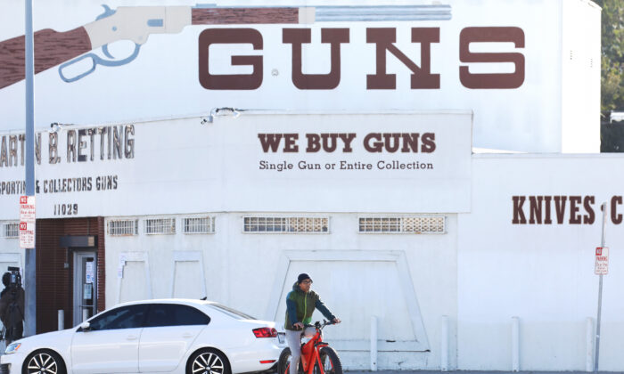 Un ciclista pasa junto a la tienda de armas Martin B. Retting en Culver City, California, el 24 de marzo de 2020. (Mario Tama/Getty Images)