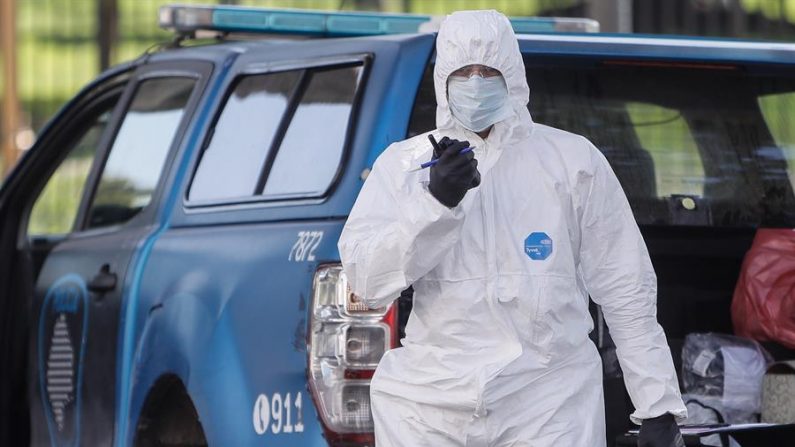 Miembros de la policía con trajes de protección contra el covid-19 realizan controles en el quinto día de la cuarentena obligatoria, el 24 de marzo de 2020, en Buenos Aires (Argentina). EFE/Juan Ignacio Roncoroni