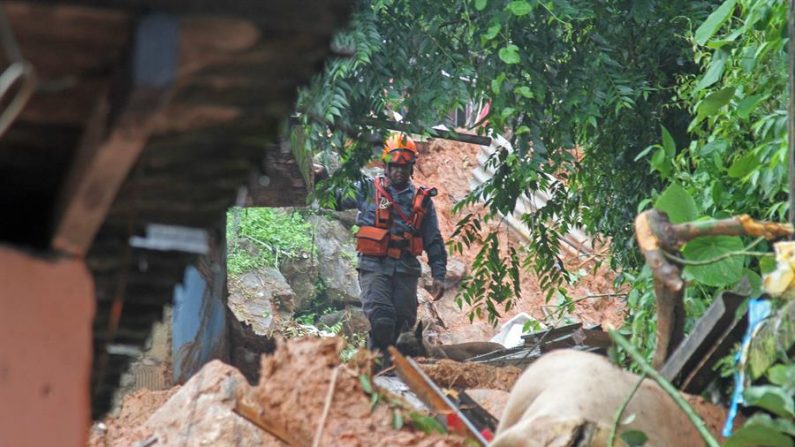 Vista el 3 de marzo de 2020 de un bombero buscando a los desaparecidos tras el derrumbe en el "Morro do Macaco Molhado", en Guarujá (Brasil). EFE/ Fernanda Luz