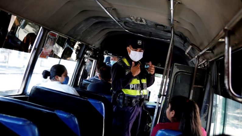 Un agente policial inspecciona que el trasporte público cumpla con normas de seguridad sanitaria en San Salvador (El Salvador). EFE/Rodrigo Sura/Archivo
