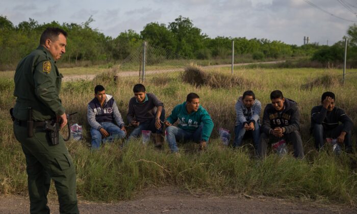 Un agente de la Patrulla Fronteriza detiene a inmigrantes ilegales poco después de que cruzaran la frontera de México a Estados Unidos el lunes 26 de marzo de 2018 en el sector del Valle del Río Grande cerca de McAllen, Texas. (Loren Elliott/AFP vía Getty Images)