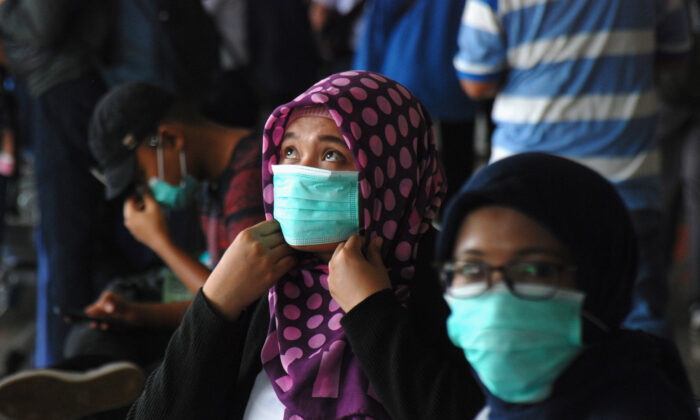 Personas con mascarillas esperan en una estación de tren en Bandung, en Indonesia, el 5 de marzo de 2020. (Timur Matahari/AFP vía Getty Images)