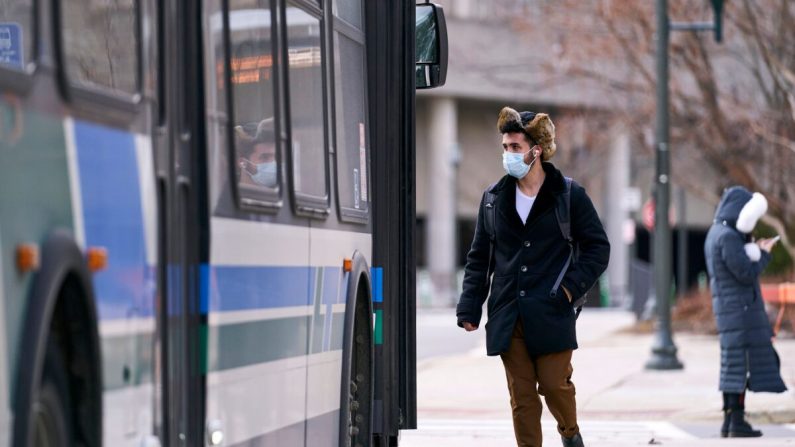 Un hombre con una máscara sube a un autobús en el campus de la Western University, en Londres, Ontario, el 13 de marzo de 2020. (Geoff Robins/AFP a través de Getty Images)