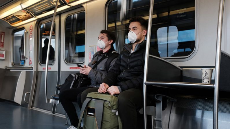 Personas usan máscaras médicas en ruta hacia el aeropuerto John F. Kennedy (JFK) mientras la preocupación por el coronavirus crece, el 7 de marzo de 2020 en la ciudad de Nueva York.  (Spencer Platt/Getty Images)
