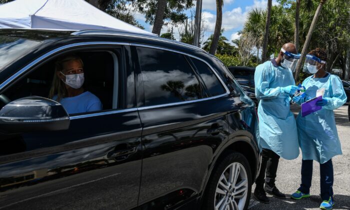 Lee Dinzik espera su prueba sentada en su auto mientras el personal médico se prepara, en un laboratorio de pruebas de coronavirus en West Palm Beach, Miami, el 16 de marzo de 2020.  (Chandan Khanna/AFP a través de Getty Images)