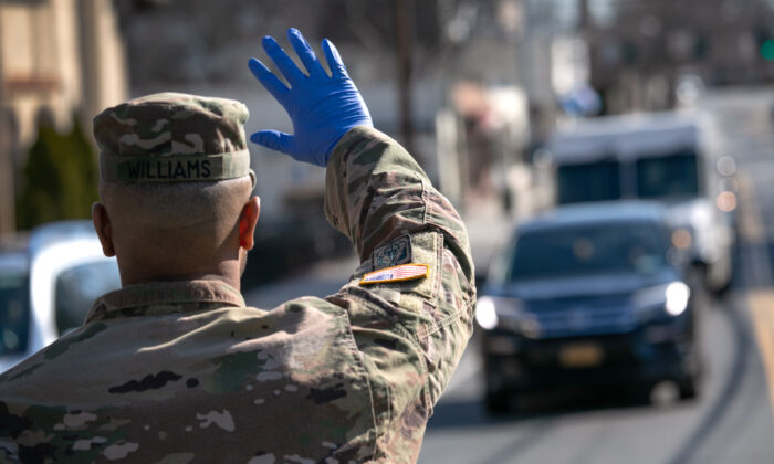 Un soldado de la Guardia Nacional de EE. UU. detiene el tráfico mientras las tropas distribuyen alimentos a los residentes locales en el centro comunitario WestCop el 18 de marzo de 2020 en New Rochelle, Nueva York. (John Moore / Getty Images)