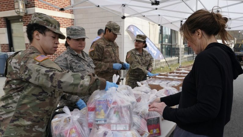 tropas de la Guardia Nacional dan comida a residentes de New Rochelle, Nueva York en la escuela secundaria de New Rochelle el 12 de marzo de 2020. (Timothy A. Clary/AFP vía Getty Images)
