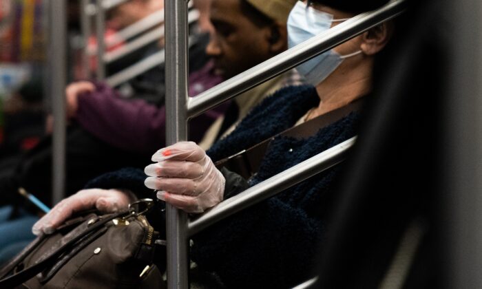 Una mujer que lleva una máscara protectora viaja en el metro de la ciudad de Nueva York, el 9 de marzo de 2020. (Jeenah Moon/Getty Images)