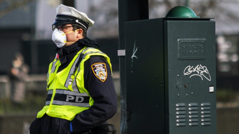Un oficial de policía de Nueva York lleva una máscara facial mientras dirige el tráfico en una calle local de la ciudad de Nueva York el 27 de marzo de 2020. (Eduardo Muñoz Álvarez/Getty Images)

