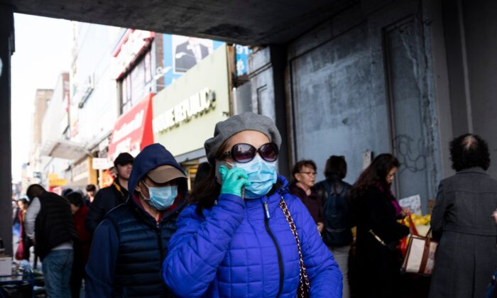 La gente usa máscaras faciales cuando camina por una calle en el barrio de Flushing del distrito de Queens en la ciudad de Nueva York el 2 de marzo de 2020.  (Johannes Eisele/AFP a través de Getty Images) 
