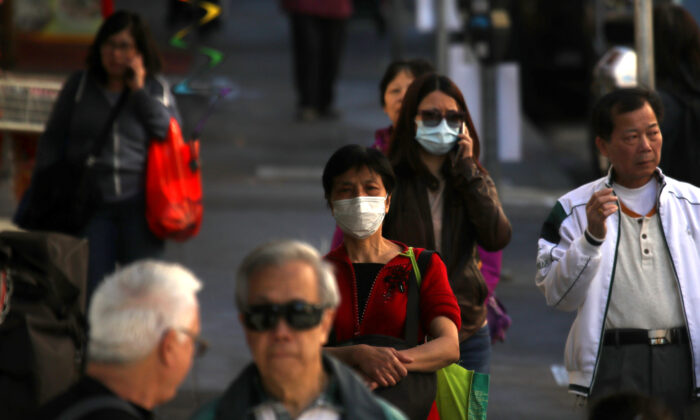 La gente usa máscaras quirúrgicas mientras camina por la Avenida Grant del Barrio Chino en San Francisco, California, el 26 de febrero de 2020. (Justin Sullivan/Getty Images)
