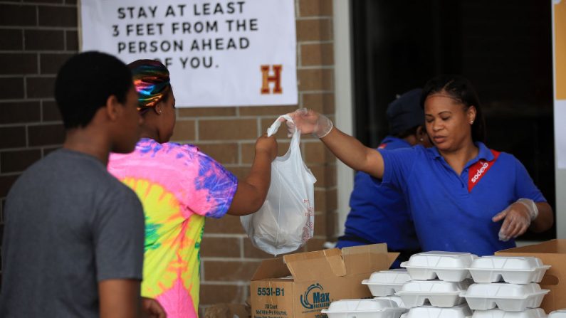 La escuela Paul Habans Charter reparte suministros, incluyendo comida, libros y computadoras a los estudiantes y a la comunidad mientras las escuelas de Louisiana cierran por un mes debido a la propagación del coronavirus (COVID-19) el 17 de marzo de 2020 en Nueva Orleans, Louisiana. (Chris Graythen/Getty Images)