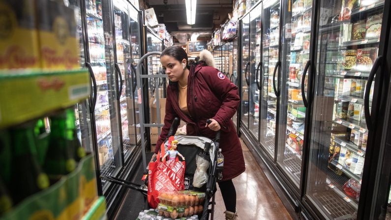 Una mujer paga en efectivo mientras usa guantes durante el horario especial abierto sólo para personas mayores y discapacitadas en el Northgate Gonzalez Market, un supermercado especializado para hispanos, en Los Ángeles, California, el 19 de marzo de 2020. (Mario Tama/Getty Images)