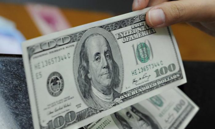 Una persona sujeta billetes de 100 dólares en una foto de archivo. (Adek Berry/AFP/Getty Images)
