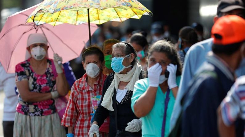 Decenas de personas hacen fila en las agencias de diferentes bancos para cobrar un bono de 300 dólares otorgados por el Gobierno, en San Salvador (El Salvador). EFE/ Rodrigo Sura/Archivo
