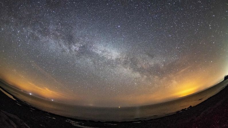 La Vía Láctea y los meteoros de la lluvia anual de meteoritos de abril de Líridas se ven en el cielo nocturno sobre Burg auf Fehmarn en la isla de Fehmarn, en el Mar Báltico, al norte de Alemania, el 20 de abril de 2018. (DANIEL REINHARDT/DPA/AFP vía Getty Images)