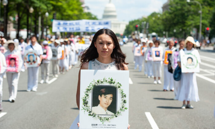 Una mujer sostiene una foto de un hombre asesinado por la persecución del régimen chino a Falun Gong, durante un desfile en Washington el 17 de julio de 2014. (Larry Dye / The Epoch Times)