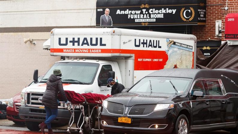 Un cuerpo es retirado de un remolque en las afueras de la funeraria Andrew T. Cleckley en Brooklyn, Nueva York, EE.UU., el 30 de abril de 2020. EFE/Justin Lane