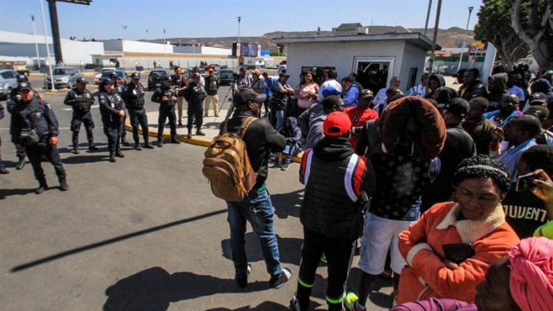 Vista de varios migrantes que se encuentran frente al cruce internacional “El Chaparral", frontera con Estados Unidos, en Tijuana (México). EFE/ Joebeth Terriquez
