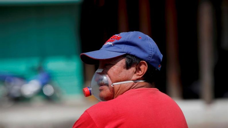 Un hombre utiliza una mascarilla improvisada hecha con un envase de gaseosa, el viernes 10 de abril de 2020, frente a la iglesia San Felipe, en Antigua (Guatemala). EFE/ Esteban Biba/Archivo
