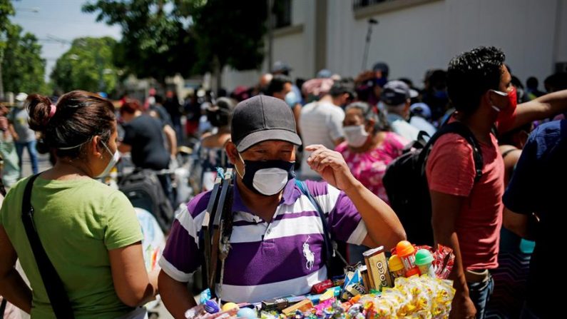 Vendedores informales de Ciudad de Guatemala protestan frente a la Casa Presidencial para exigir apoyo económico debido a la crisis por las restricciones comerciales y de movilidad impuestas por el Gobierno en su intención de evitar la propagación del COVID-19. EFE/Esteban Biba
