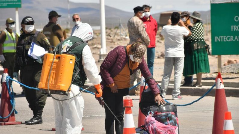 Una ciudadana boliviana proveniente de Chile se somete al control sanitario para entrar a su país y pasar una cuarentena de 14 días en un campamento en la localidad fronteriza de Pisiga, en el departamento de Oruro (Bolivia). EFE/Emilio Huascar
