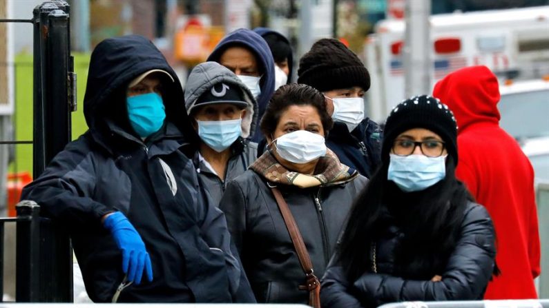 Las personas que usan máscaras protectoras hacen cola frente al Hospital Elmhurst en Queens, Nueva York, EE.UU., el 02 de abril de 2020. EFE/Peter Foley