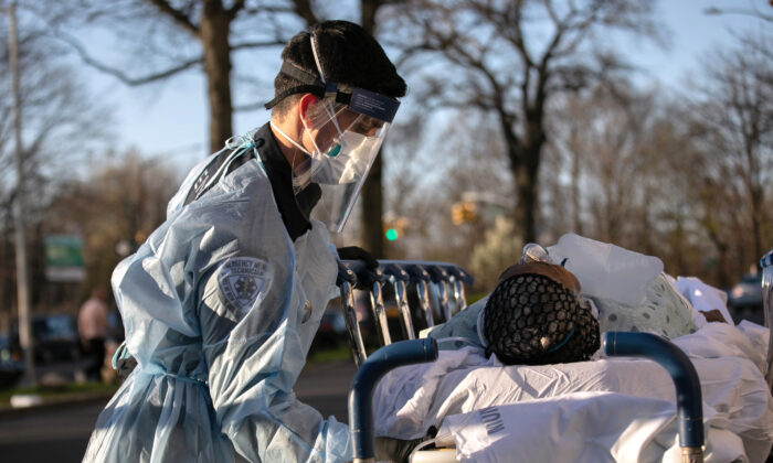 Un paramédico atiende a un paciente con COVID-19 que llega al Centro Médico Montefiore del Campus de Wakefield en el distrito del Bronx de la Ciudad de Nueva York el 6 de abril de 2020. (John Moore/Getty Images)