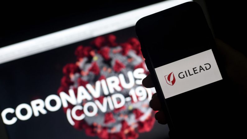 El logo de Gilead aparece en un smartphone junto a una pantalla que muestra un gráfico de un virus del PCCh en Arlington, Va., el 25 de marzo de 2020. (Olivier Douliery /AFP vía Getty Images)
