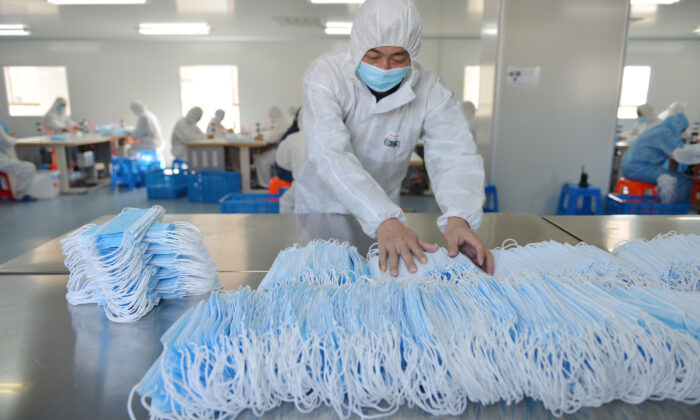 Un trabajador produce mascarillas protectoras en una fábrica en Qingdao, China, el 6 de febrero de 2020. (STR/AFP vía Getty Images)