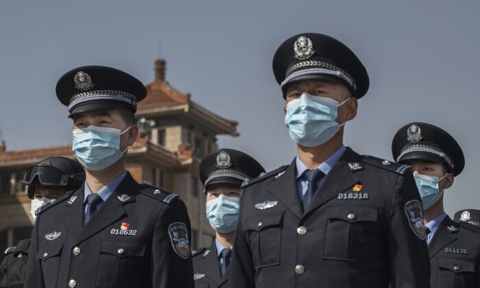 Oficiales de policía chinos usan máscaras protectoras en la estación de trenes de Beijing el 4 de abril de 2020. (Kevin Frayer/Getty Images)