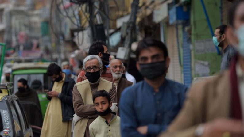 Personas pakistaníes hacen fila para pagar facturas de servicios públicos en un banco durante un bloqueo nacional impuesto por el gobierno como medida preventiva contra el coronavirus COVID-19 en Rawalpindi el 30 de marzo de 2020. (FAROOQ NAEEM/AFP a través de Getty Images)
