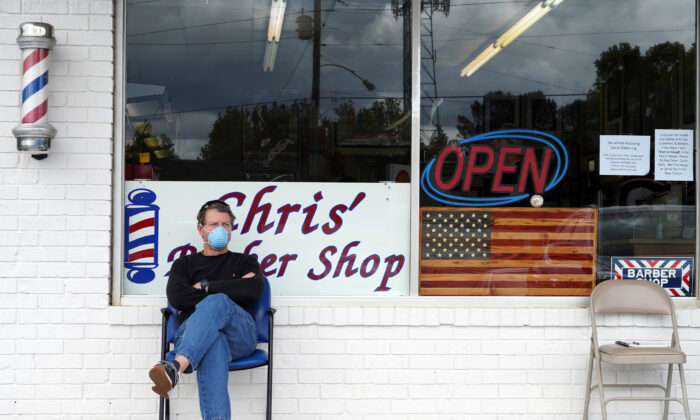 Dan Settle se sienta afuera de Chris 'Barber Shop mientras espera su turno para un corte de pelo en Lilburn, Georgia, el 24 de abril de 2020. (Chappell / AFP a través de Getty Images)