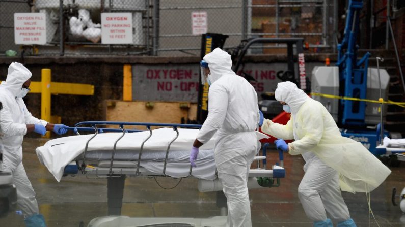 El personal médico traslada a un paciente fallecido a un camión refrigerado que sirve como morgues de turno en el Brooklyn Hospital Center el 09 de abril de 2020 en la ciudad de Nueva York. (Angela Weiss/AFP a través de Getty Images)