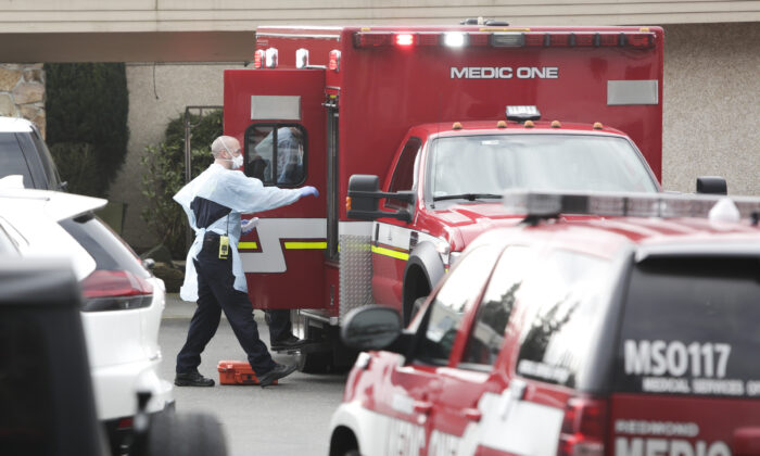 El personal de la ambulancia se prepara para transportar a un residente del hogar de ancianos Life Care Center, donde algunos pacientes han muerto a causa del COVID-19 en Kirkland, Washington. (Jason Redmod/AFP vía Getty Images)