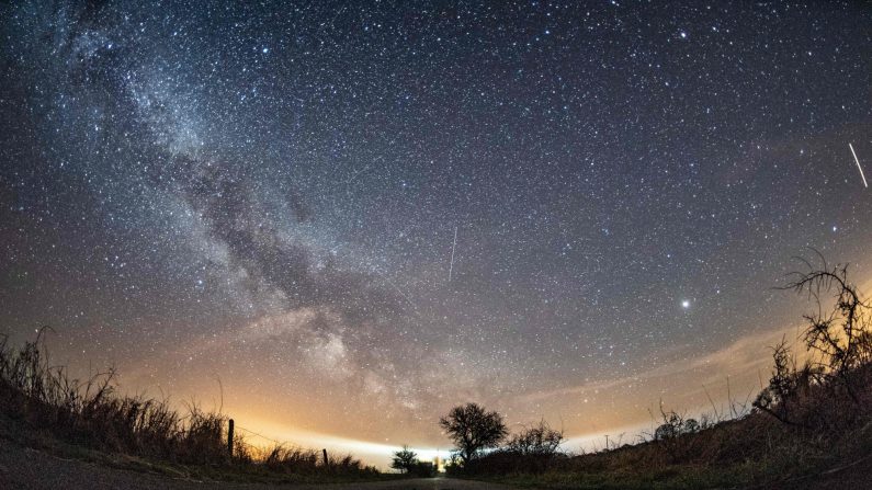 La Vía Láctea y los meteoros de la lluvia anual de meteoritos de abril de Líridas se ven en el cielo nocturno sobre Burg auf Fehmarn en la isla de Fehmarn, en el Mar Báltico, al norte de Alemania, el 20 de abril de 2018. (DANIEL REINHARDT/DPA/AFP vía Getty Images)