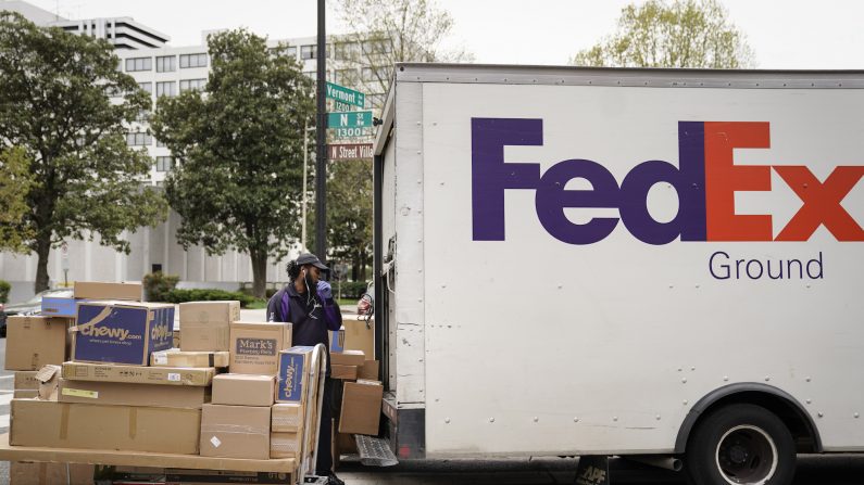 Un trabajador de FedEx descarga paquetes de su camión de reparto el 31 de marzo de 2020, en Washington, D.C. (Drew Angerer/Getty Images)
