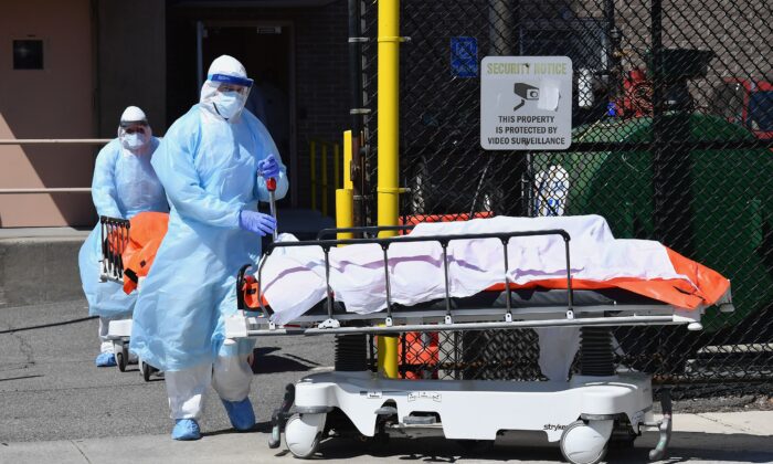 El personal médico mueve los cuerpos desde el Centro Médico de Wyckoff Heights a un camión refrigerado en la ciudad de Nueva York, el 2 de abril de 2020. (Angela Weiss/AFP/Getty Images)