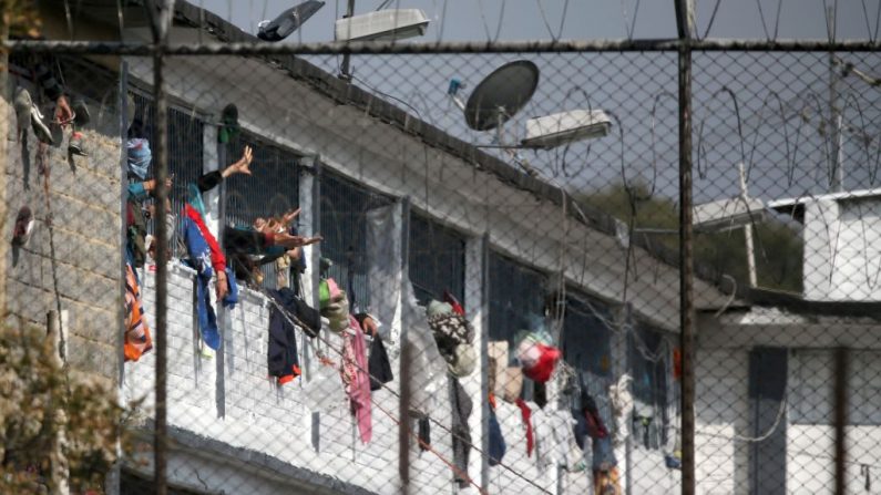 Los reclusos extienden sus manos en la prisión Modelo de Bogotá (Colombia) después de un motín el 22 de marzo de 2020. (DANIEL MUNOZ/AFP vía Getty Images)