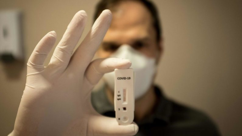 Un médico muestra un kit de test rápido de sangre para COVID-19 en una clínica de la favela de Rocinha, Río de Janeiro, Brasil, el 15 de abril de 2020. (FLORIAN PLAUCHEUR/AFP vía Getty Images)