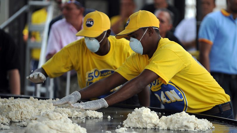 Los cocineros del gigante de la alimentación venezolana Empresas Polar hacen una enorme arepa (torta de maíz) en Caracas (Venezuela) el 23 de marzo de 2011. (JUAN BARRETO/AFP a través de Getty Images)