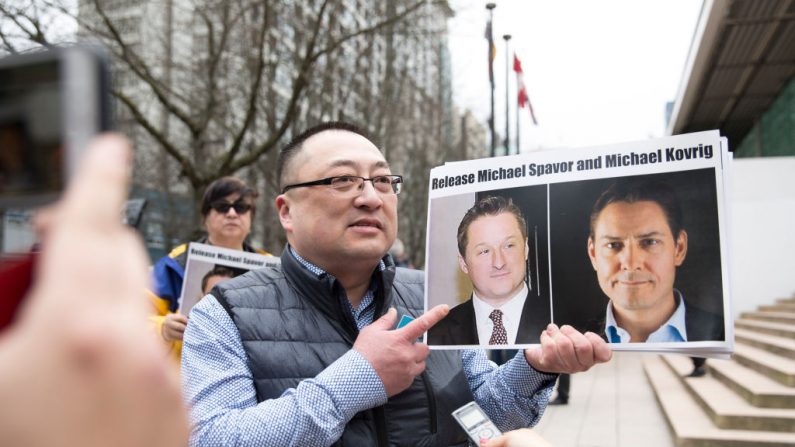 Louis Huang de Vancouver Freedom and Democracy for China, tiene fotos de los canadienses Michael Spavor y Michael Kovrig, que fueron detenidos por China, fuera de la Corte Suprema de la Columbia Británica, en Vancouver, el 6 de marzo de 2019, mientras la Directora Financiera de Huawei, Meng Wanzhou, comparece ante el tribunal. (Jason Redmond/AFP vía Getty Images)