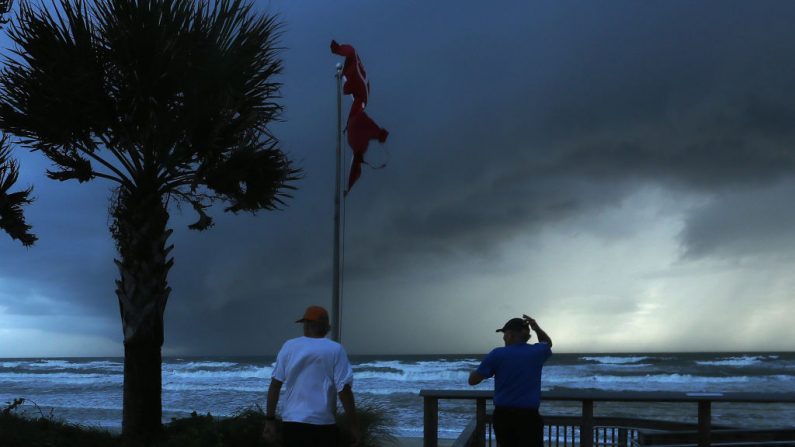 Dos hombres observan una tormenta que se aproxima, causada por el huracán Dorian, que se avecina en el Océano Atlántico el 3 de septiembre de 2019 en Ormond Beach, Florida (EE.UU). (Mark Wilson/Getty Images)