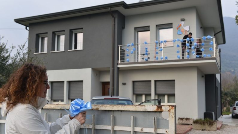 Los miembros de la familia ponen decoraciones en su casa mientras celebran el nacimiento de un recién nacido en Zovon, cerca de Venecia, Italia, el 24 de febrero de 2020, en medio de los temores por la propagación del virus del PCCh. (MARCO SABADIN/AFP vía Getty Images)