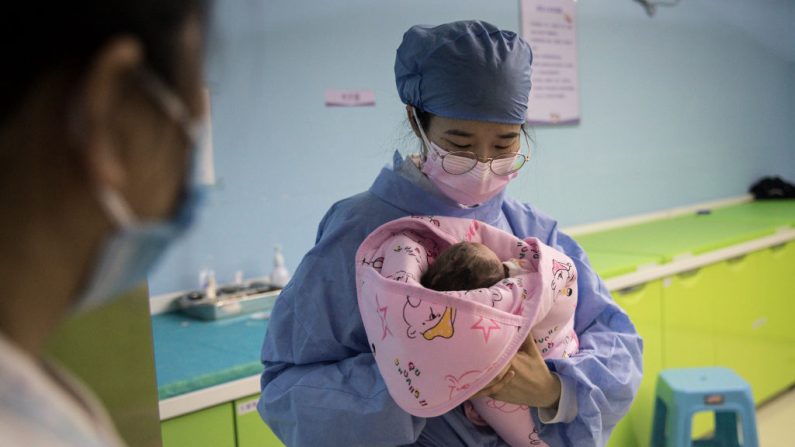 Una enfermera sostiene a un recién nacido en un hospital obstétrico privado el 21 de febrero de 2020 en Wuhan, Hubei, China. (Foto de Getty Images)